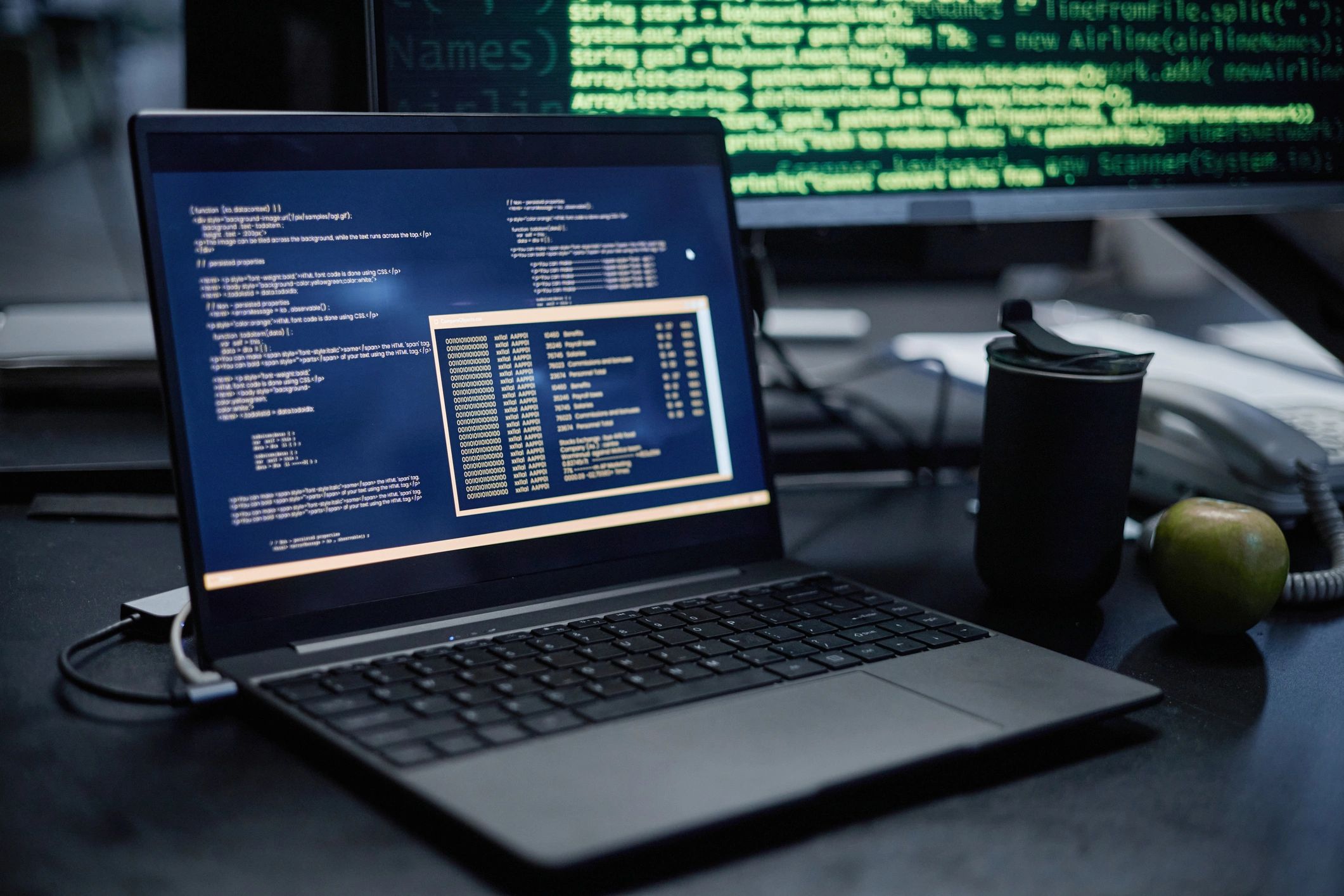 Laptop displaying programming code in a modern workspace