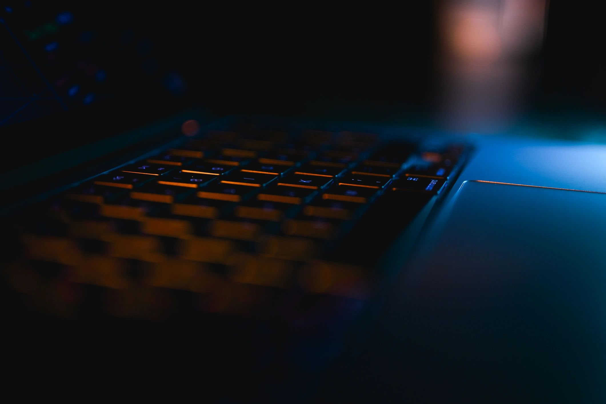 Orange-lit laptop keyboard representing conversion-focused digital sales copy